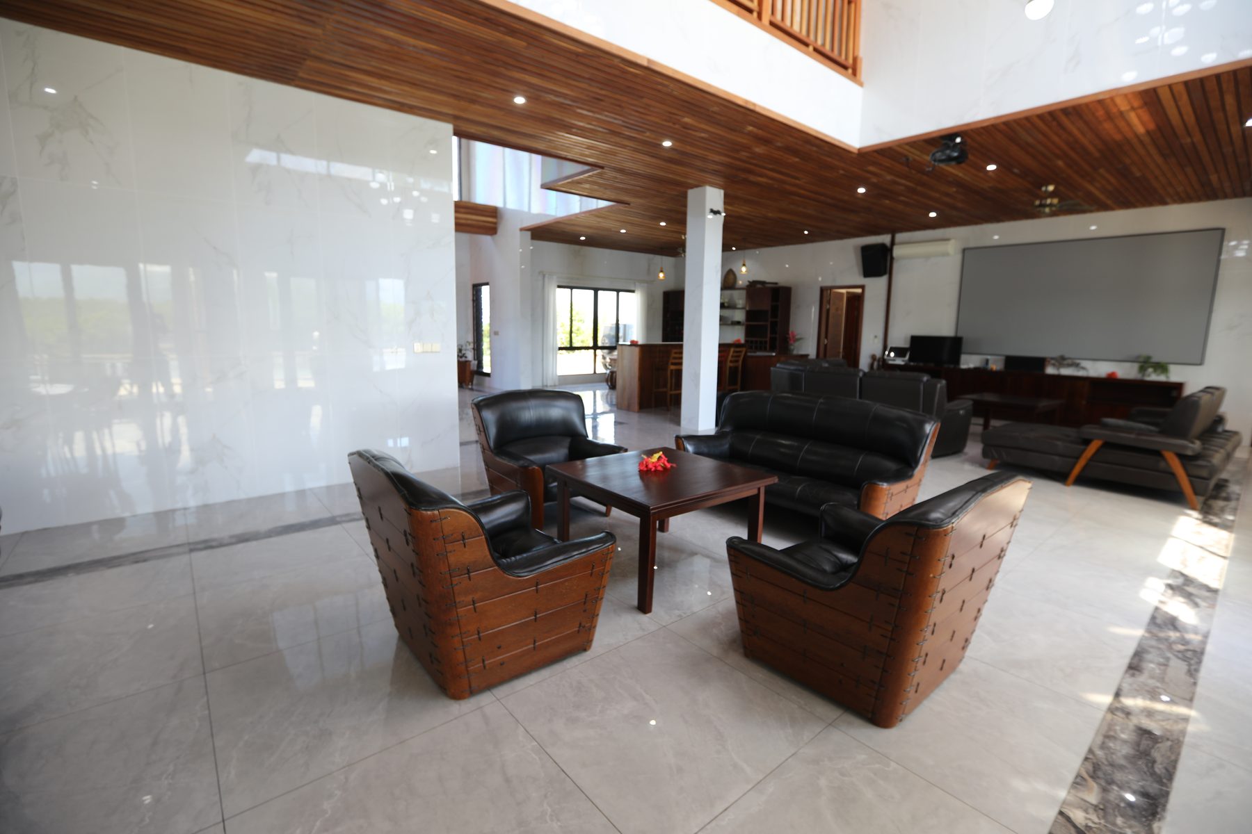 Open-plan great room with timber-lined ceiling, lounges and dining