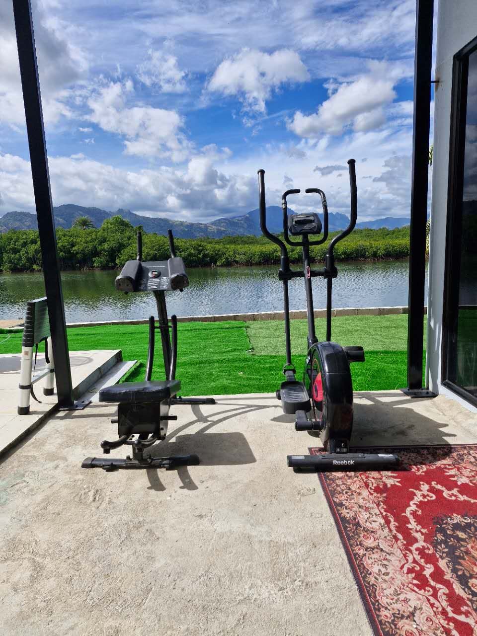Gym equipment set up under cover looking over the lake