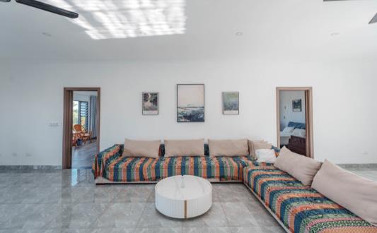 Upstairs living room with sofas opening onto the balcony