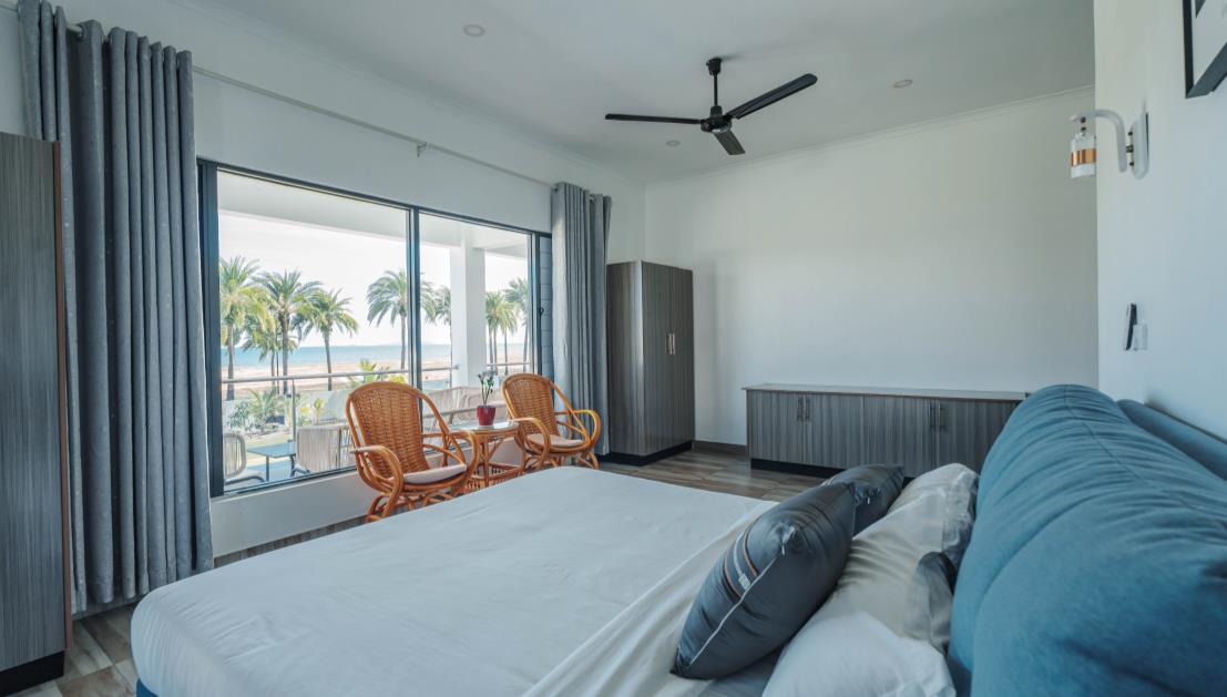 Upstairs bedroom 201 with king bed and sea-view balcony doors